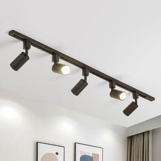 three lights are on the ceiling above a bed