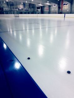 an empty ice rink with some black balls on it