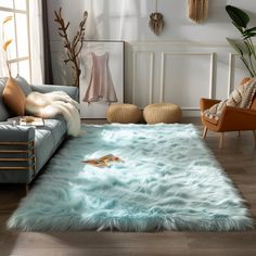 a living room filled with furniture and a rug on top of a hard wood floor