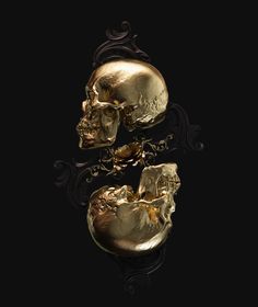 two gold skulls sitting on top of each other