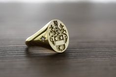 "gold diamond family crest signet ring delicately engraved with your family crest or any other initials or image you want ♡ the stones are cubic zirconia the ring has solid back. deep and detailed engraving very delicately handcrafted unisex - looks super cool on both women & men we offer real diamond option as the stone. for that, please send us a message ♡ there is an additonal cost of 12 usd for inside engravings. if you want any inside engravings please don't forget to add the \"Side or Gold Engraved Ring With Coat Of Arms For Anniversary, Gold Jewelry With Coat Of Arms In 14k Gold, Elegant Oval Signet Ring With Coat Of Arms, Luxury Signet Ring With Coat Of Arms For Anniversary, Luxury Yellow Gold Signet Ring With Coat Of Arms, Luxury Yellow Gold Coat Of Arms Signet Ring, Luxury Engraved Ring With Single Cut Diamonds As Gift, Heirloom Yellow Gold Coat Of Arms Jewelry, Engraved Yellow Gold Diamond Signet Ring