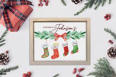 a christmas card with stockings and stockings hanging on the wall next to evergreen branches, pine cones