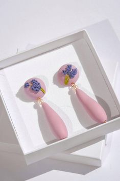 Blooming with style - introducing our new flower-inspired earrings. Lovingly crafted by hand, each earring is individually sculpted, inspired by the delicate and fragrant lavender flower. And as a finishing touch, the earrings are adorned with stunning freshwater pearls. ▫️ DETAILS ▫️ - Polymer clay in lavender purple shade.  - Hand-sculptured lavender flowers.  - Hand-sculptured beads (they are purposely not perfectly symmetric, as they have been crafted by hand and wanted to showcase their org Lavender Earrings, Lavender Flower, Purple Pearl, Earrings Elegant, Floral Jewellery, Lavender Purple, Lavender Flowers, Earrings Statement, Travel Jewelry