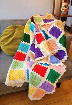 a crocheted blanket sitting on top of a couch