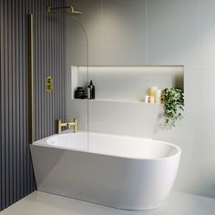 a white bath tub sitting in a bathroom next to a shower head and toilet paper dispenser