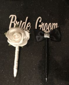 two wedding cake toppers with black and white flowers on them, one for bride and the other for groom