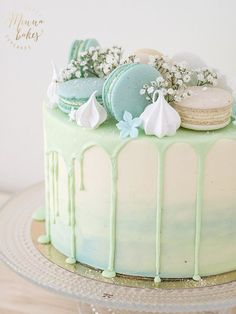 a green cake with white frosting and cookies on top is sitting on a platter