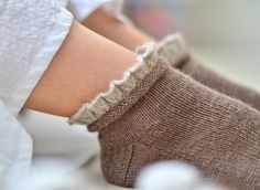 a woman's arm with a pair of knitted socks on top of it