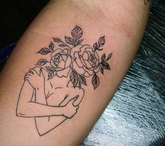 a black and white photo of a woman with flowers on her arm