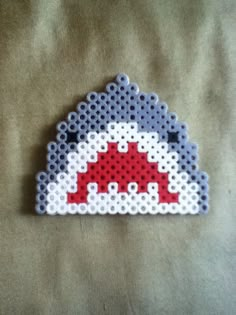 a piece of art made out of perler beads on a sheet of fabric with the letter d in red, white and blue