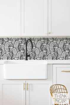 a white kitchen sink sitting under a faucet next to a wall mounted dishwasher