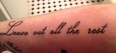 a person with a tattoo on their arm that says leave out all the rest in cursive writing