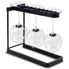 three wine glasses sitting on top of a metal stand with glass holders in the middle