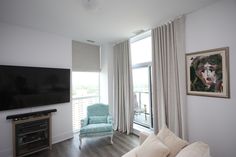 a living room filled with furniture and a flat screen tv on top of a wooden floor