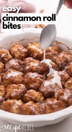 cinnamon roll bites being drizzled with icing in a white baking dish