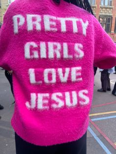 a woman wearing a pink sweater that says pretty girls love jesus