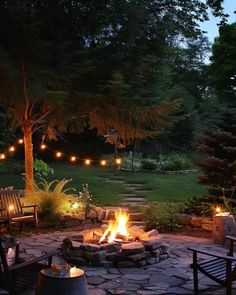 a fire pit surrounded by chairs and lights