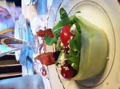 a salad with bacon and tomatoes in a bowl