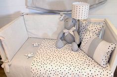 a teddy bear sitting on top of a bed next to pillows