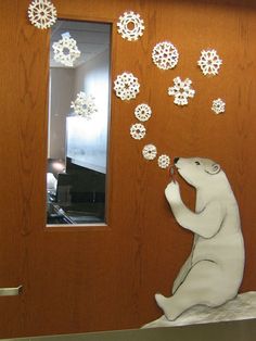 a polar bear is blowing snowflakes on the door