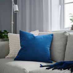 a blue pillow sitting on top of a white couch