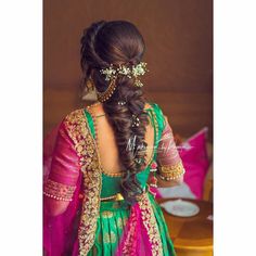 a woman in a green and pink dress with her hair styled into a half updo