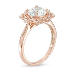 Striking and splendid, this vintage-inspired ring is a treasured keepsake in the making. Crafted in precious 10K rose gold, this pretty style showcases an 8.0mm lab-created shimmering white sapphire wrapped in a sculpted sunburst of sparkling petite diamonds and intricate milgrain detailing. Captivating with 1/6 ct. t.w. of diamonds and a bright polished shine, this design speaks to her elegant taste. This ring is available in size 7 only. Classic Diamond Flower Ring In Rose Gold, Classic Rose Gold Jewelry With Center Stone, Classic Rose Gold Diamond Flower Ring, Heirloom Rose Gold Diamond Flower Ring, 14k Rose Gold Diamond Ring With Halo Setting, 14k Rose Gold Halo Setting Diamond Ring, Classic Rose Gold Cluster Ring With Diamond Cut, Vintage Round Cut Jewelry With Halo Design, Vintage Rose Gold Round Cut Diamond Ring