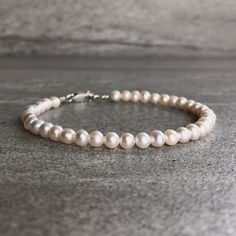 This freshwater pearl bracelet is the perfect wedding accessory. The minimalist design allows the beauty of the pearls to be the focus. At checkout, choose a gold or sterling silver clasp for your bracelet. * METAPHYSICAL PROPERTIES OF PEARLS * peace prosperity feminine energy integrity wisdom faith Free gift with every crystal jewelry purchase from Gems by Kelley: a beautiful card with the metaphysical properties of each crystal in your order. Would you like to see more freshwater pearl jewelry Minimalist Wedding Jewelry, Modern Pearl Jewelry, Bead Stretch Bracelets, Gold Stretch Bracelet, Bracelets Etsy, Leather Anniversary, Freshwater Pearl Jewelry, Simple Pearl, Pearl Bracelets