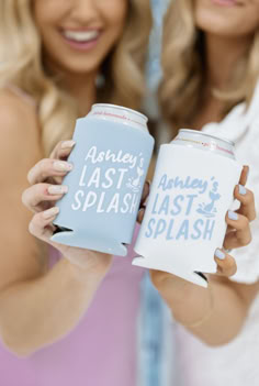 two beautiful women holding up cans of beer