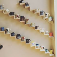 there are many mugs on the shelves in this room and one is upside down