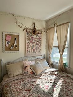 a bed sitting in a bedroom next to a window with curtains on the windowsill