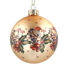 a glass ornament with holly and mushrooms on it's side, hanging from a gold chain