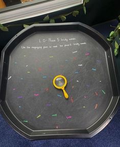 a yellow magnifying glass sitting on top of a black tray with writing on it