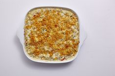 a casserole dish with cheese and seasoning in it on a white surface