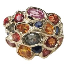 14 karat multicolored sapphire cluster ring, containing 25 round sapphires (orange, yellow, blue, green and lavender) of very fine gem quality weighing 6.43cts. This ring is a size 7 but we will size to fit for free. Luxury Multi-stone Classic Sapphire Ring, Luxury Elegant Cluster Gemstones, Luxury Multi-stone Gold-toned Gemstones, Luxury Multicolor Round Gemstones, Luxury 22k Gold Multicolor Jewelry, Luxury Multicolor Jewels Gemstones, Multicolor Oval Multi-stone Cluster Ring, Multicolor Round Sapphire Ring Fine Jewelry, Multicolor Sapphire Ring Fine Jewelry