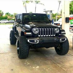 a black jeep parked in front of a gas station