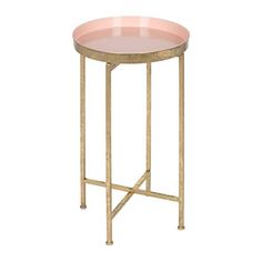 a round table with gold metal legs and pink glass top on an isolated white background