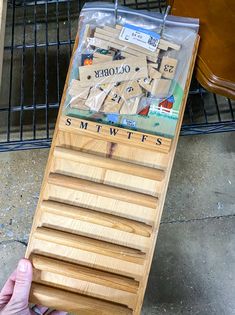 a person holding a wooden board with letters on it