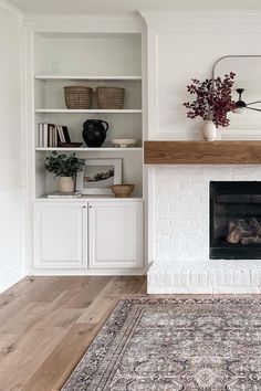 a living room with a fire place and bookcases on either side of the fireplace