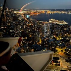 the city lights are lit up at night as seen from an observation point on top of a skyscraper