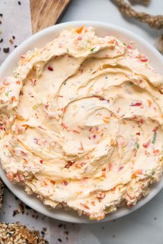 a white bowl filled with cream cheese and sprinkles