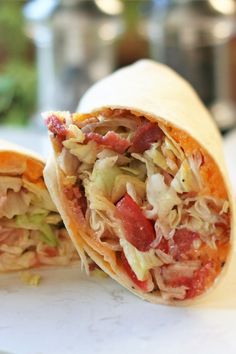 a burrito cut in half sitting on top of a cutting board