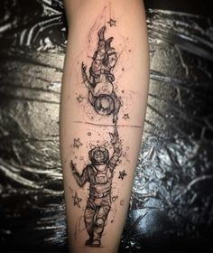 a tattoo on the leg of a person wearing an astronaut suit and holding a rocket