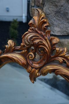 an ornate gold mirror sitting next to a stone wall