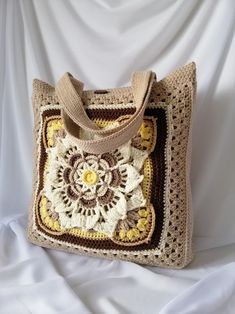 a crocheted bag sitting on top of a white sheet