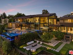 an aerial view of a modern house with pool and hot tub in the foreground