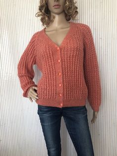 a female mannequin wearing a red sweater and jeans with her hands on her hips