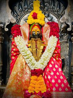 the statue is decorated with flowers and garlands