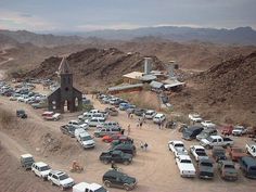 a parking lot full of cars and trucks in the desert