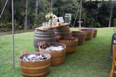 several wooden barrels are lined up on the grass